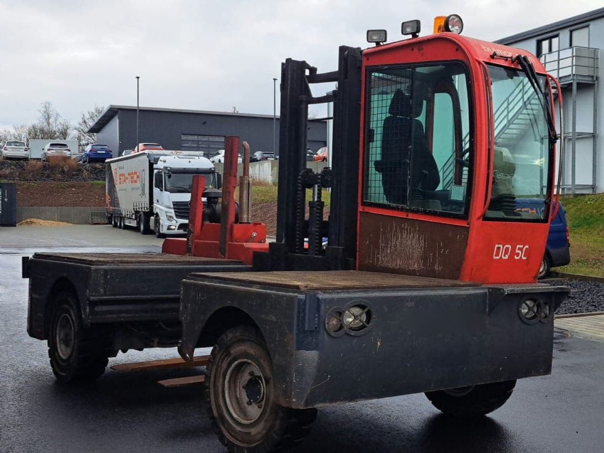 Seitenstapler aus dem STA-TECH-Mietpark auf dem Hof, im Hintergrund ein Lkw